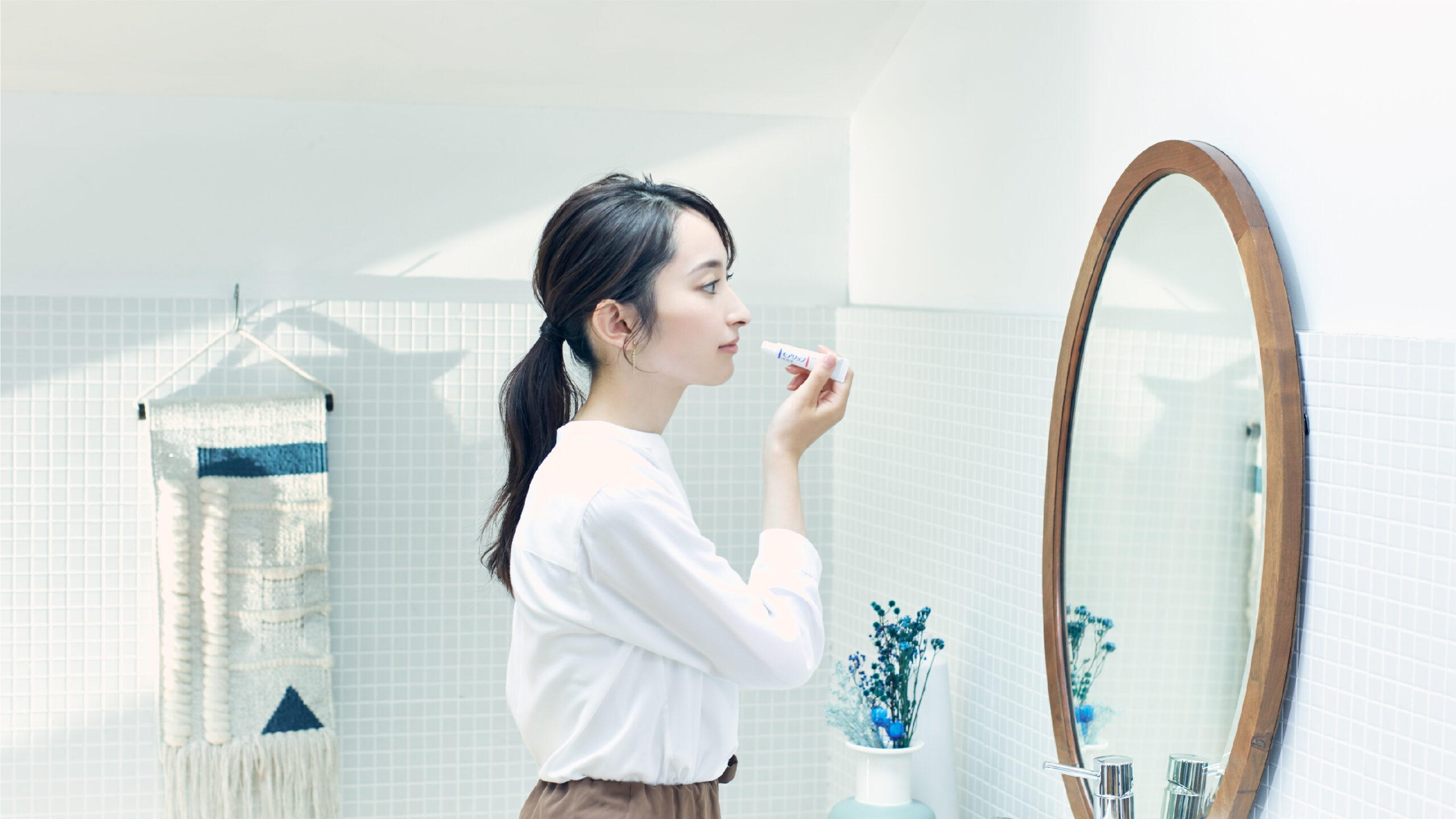 資生堂原廠使用情境,使用者拿著MOILIP軟管在鏡前塗唇